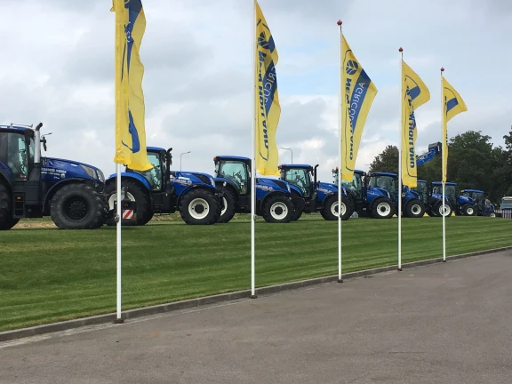 New Holland trekkers op rij met vlaggen